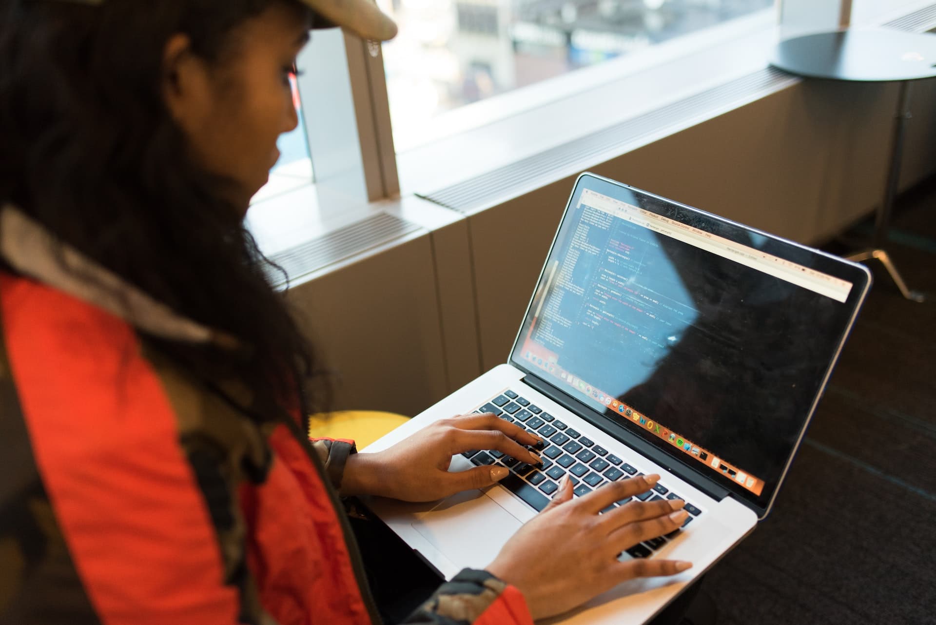 A female programmer looking at a laptop with code